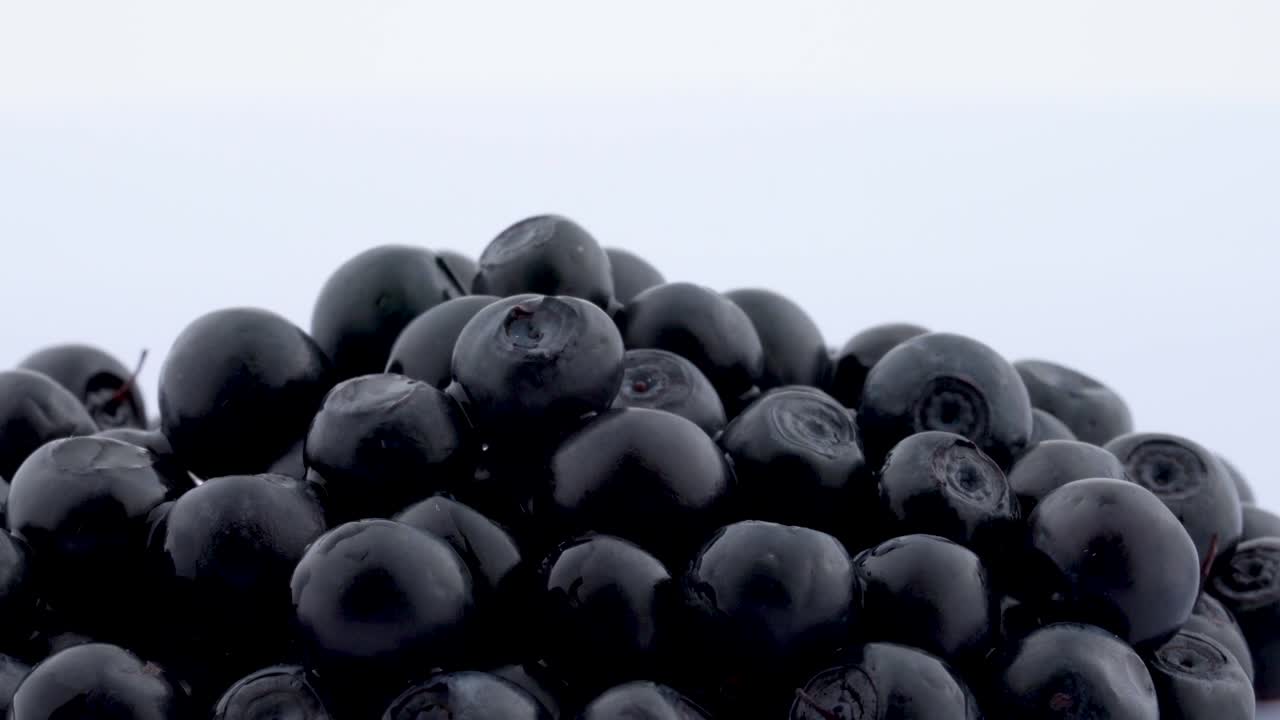 Macro of several blueberries rotating on the on the turntable isolated on the white background. Close up.