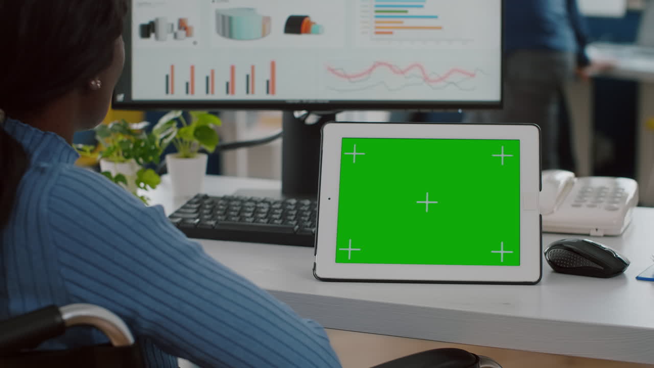 africano inmovilizado mirando una tableta digital con pantalla verde