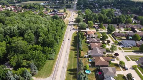 dichotomy of suburbia and a forest shown in this tracking shot over a lightly busy street