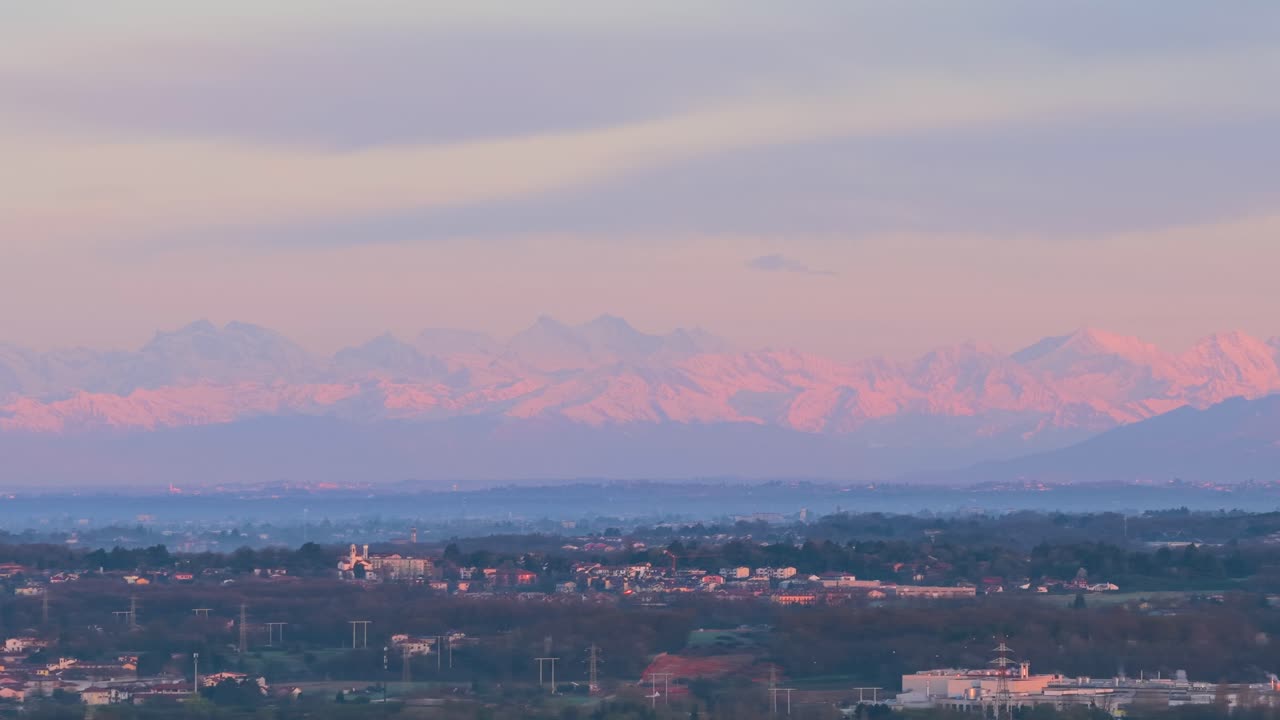The Alps mountains at sunset, tinged with pink, seen from Vimercate, Lombardy, Italy