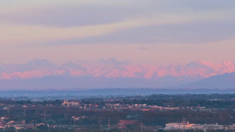 the alps mountains at sunset, tinged with pink, seen from vimercate, lombardy, italy
