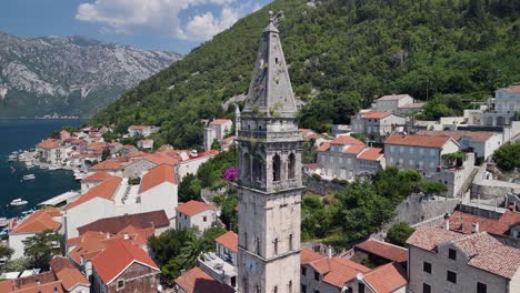 aerial rises up bell tower of medieval st nicholas church in perast mne