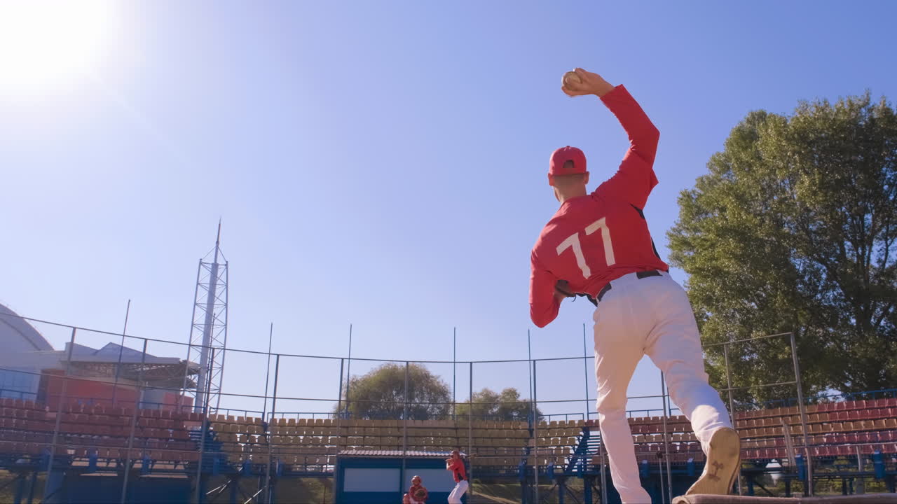 A baseball pitcher is seen in action on the field performing under the bright sunlight