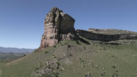 Blue-sky-aerial-to-dramatic-rock-cliff-formation,-Queen-Victoria-Rock