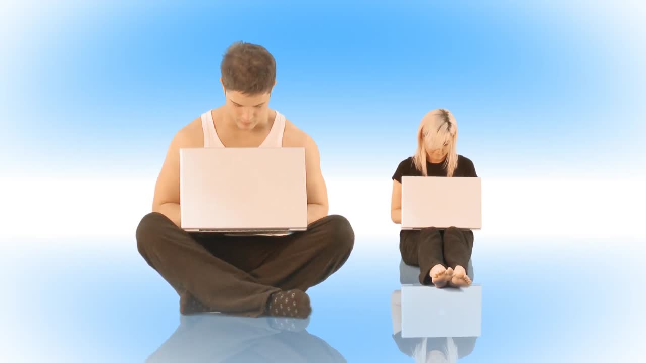 pareja trabajando en portátiles