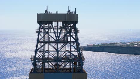 aerial close-up of oil rig platform towers with surrounding calm blue ocean, near the caribbean coast