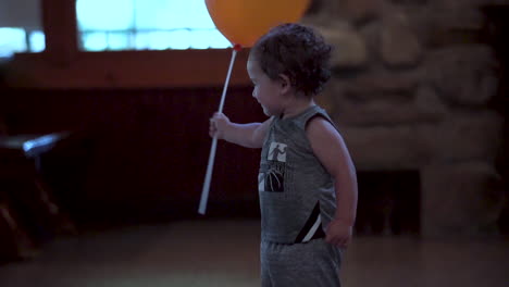 niño hispano mexicano biracial con un globo naranja