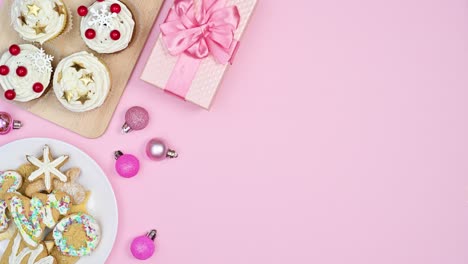 pastel pink theme with christmas cookies and ornaments come out from pink gift. stop motion