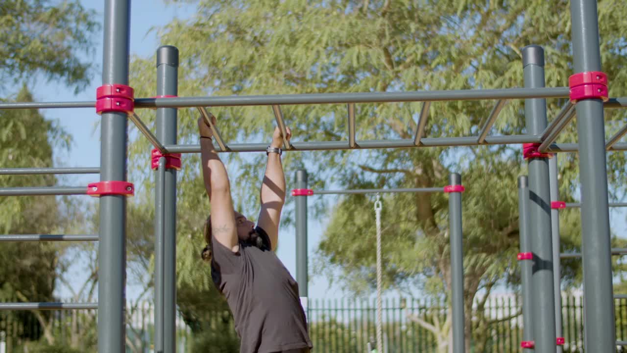남성 운동 선수가 밖의 원 ⁇ 이 바에서 운동하는 측면 전망.