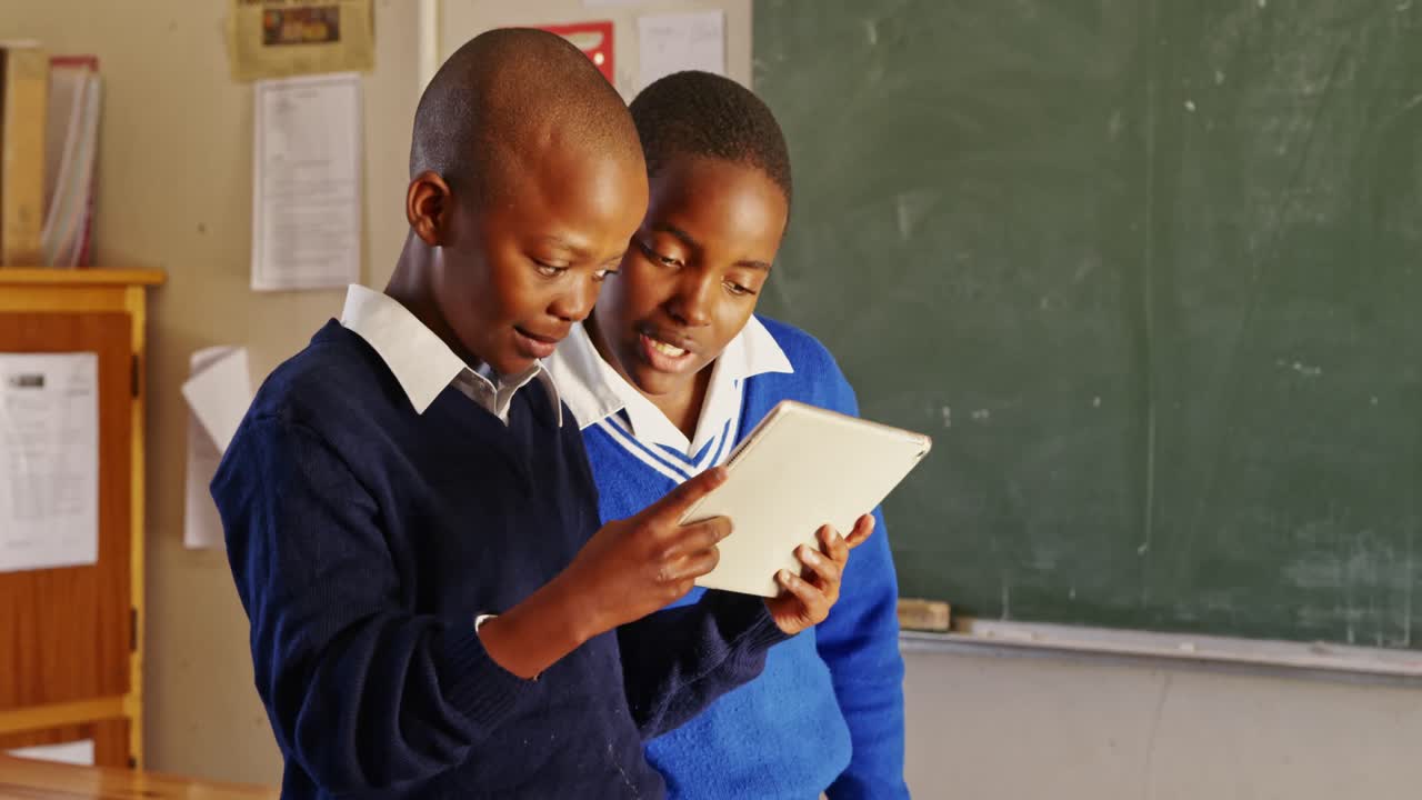 Schoolboys using a tablet during a break at a township school 4k