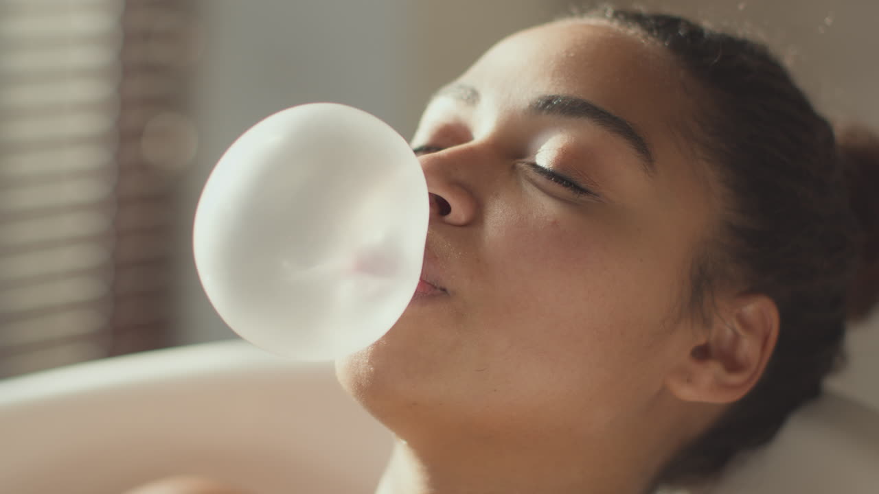 Woman blowing a bubble in a bathtub