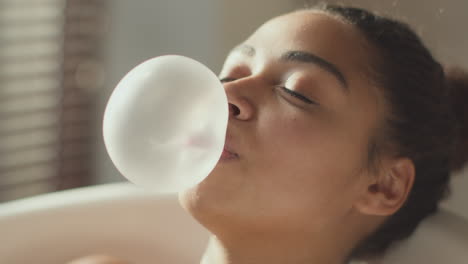 woman blowing a bubble in a bathtub