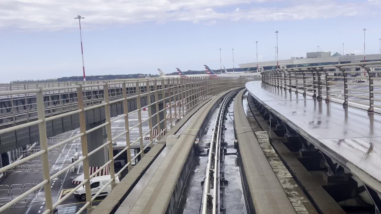 First view of skybridge monorail train moving along a curved track, linking the satellite terminal to the main terminal at Rome Fiumicino Airport, Italy