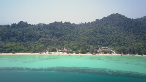 Luftaufnahme-Der-Wunderschönen-Insel-Mit-Unterkunft-Am-Strand-In-Thailand---Kamera-Rückwärts-Verfolgen