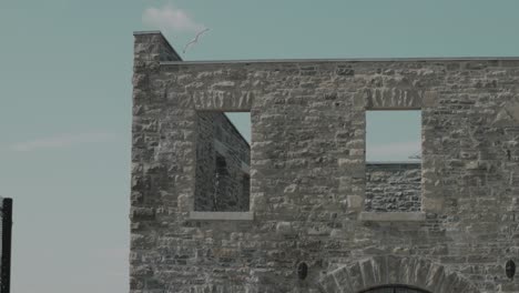 exterior shell of a abandoned old industrial style stone heritage hydro power generation complex on chaudière island in ottawa, canada in slow motion