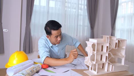 young architect working on new architectural house model