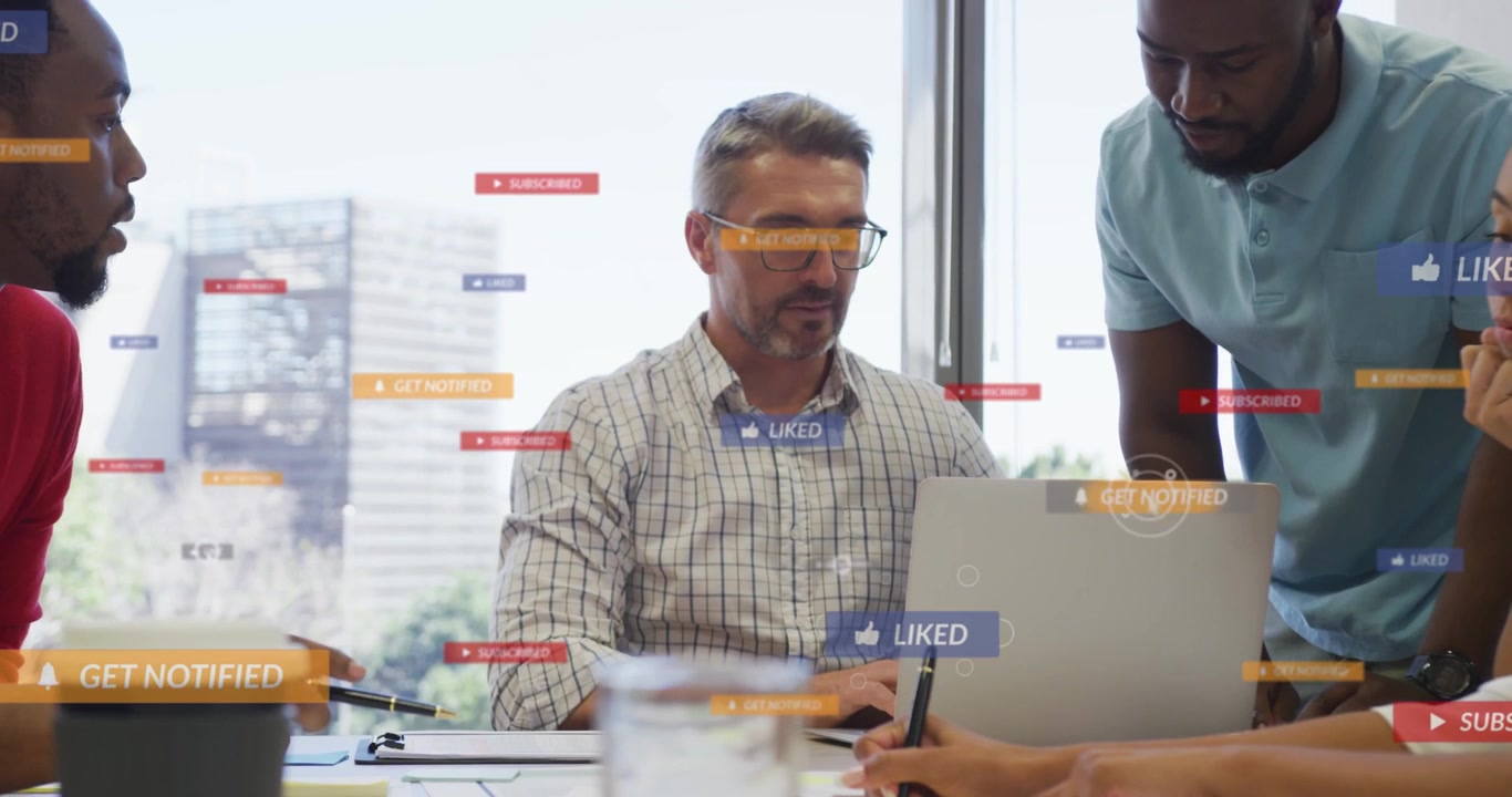 Seated man with glasses reaching, pointing, typing on laptop while badges floating showing interest