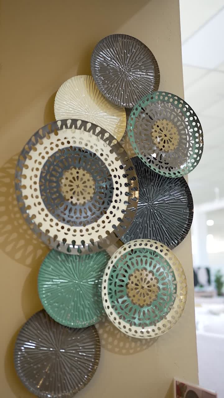 Una bellissima disposizione di piatti decorativi in vari colori e design aggiunge un tocco di stile a questo spazio interno moderno, migliorando l'ambiente generale e il fascino estetico.