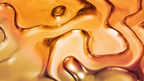 looped abstract background with wavy sparkling golden liquid pattern on shiny glossy surface. viscous yellow fluid like surface of gold foil or brilliant glass. beautiful creative festive backdrop.