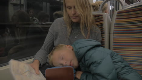 mother and sleepy child in underground train