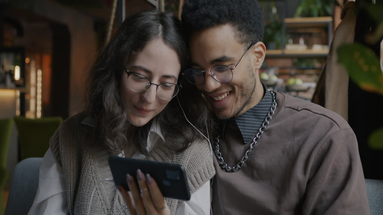 Couple watching video call in cafe