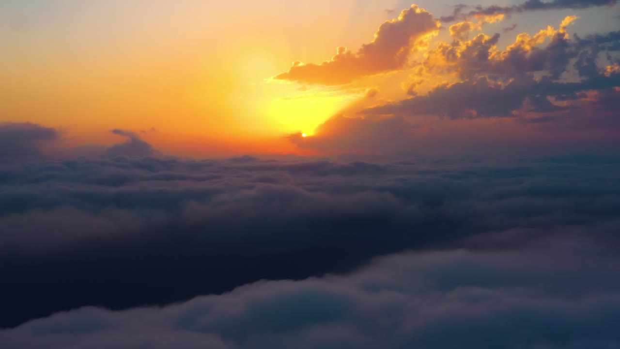 Flying over the clouds with the late sun. Sunrise or sunset colorful sky background.