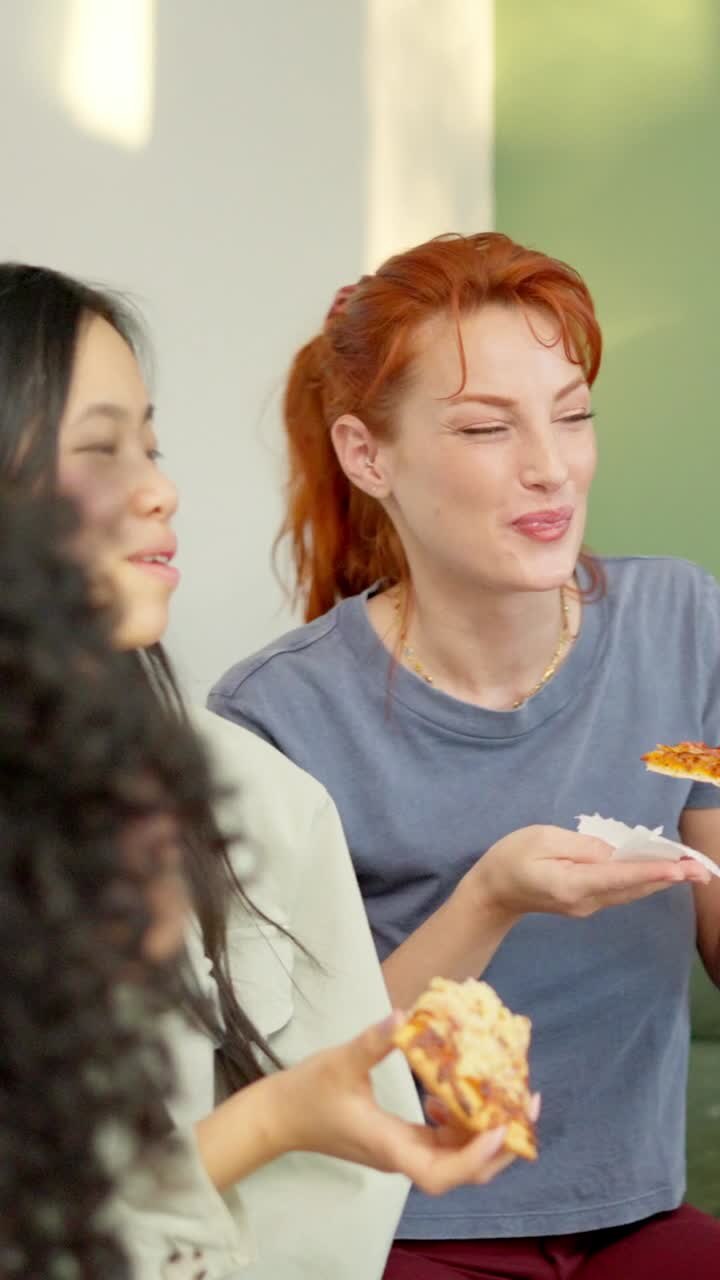 Friends chilling and smiling eating pizza together at home