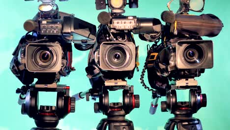 zooming-in footage of three camcorders in a studio