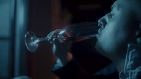 man tasting red wine in a dark restaurant