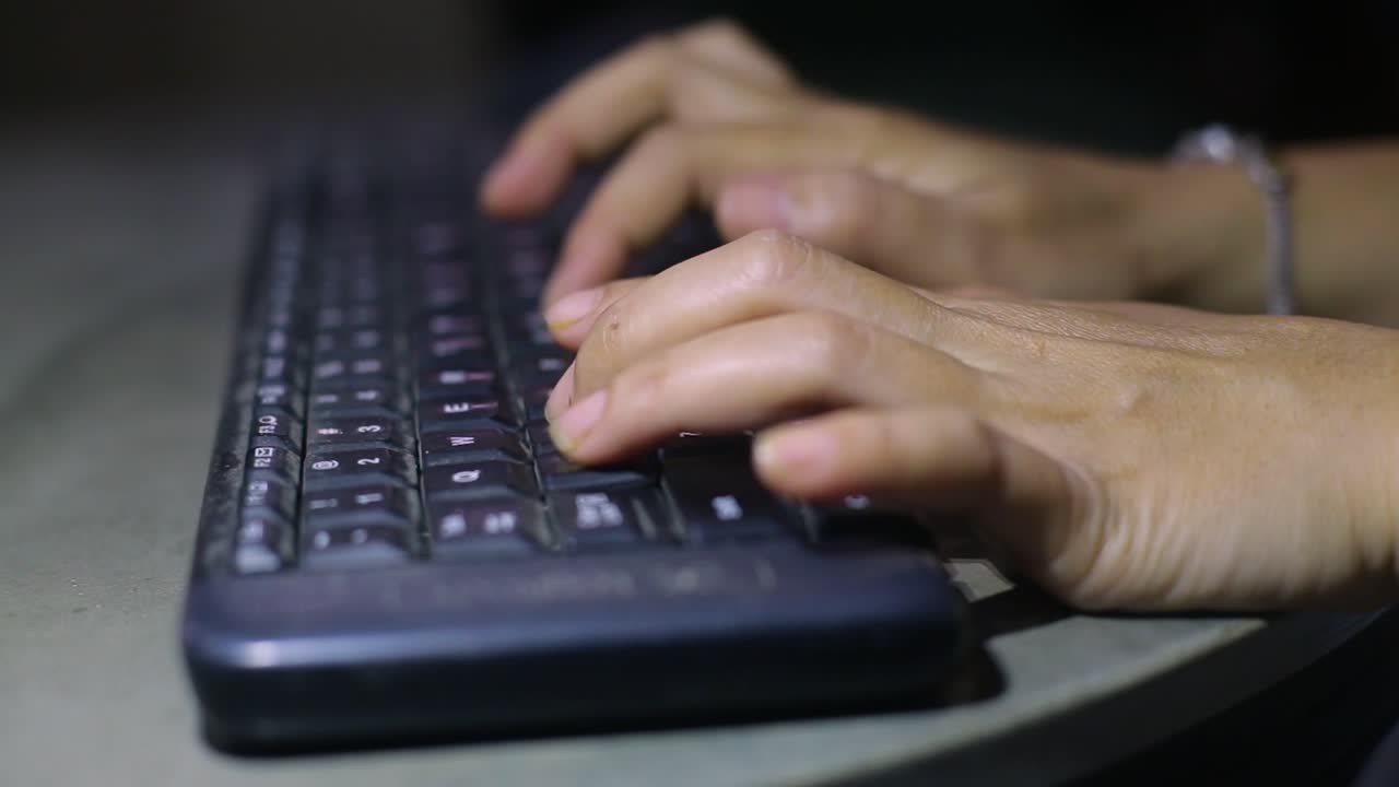 teclado de escritura manual adicto al trabajo en la oscuridad de la noche con luz de pantalla de computadora con noir trabajando en el lugar de trabajo o concepto de crimen cibernético de piratas informáticos