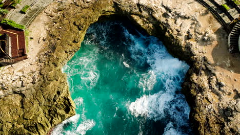 cave pool on the edge of rocky cliffs on devil's tears in nusa lembongan, bali indonesia