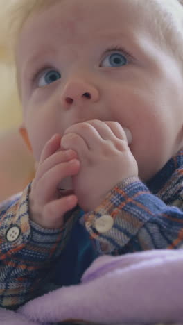 cute little boy in warm clothes nibbles detail of inhaler standing at soft bed in light children room extreme close view