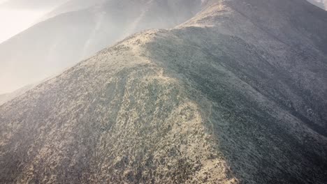 Tiro-De-Drone-De-La-Cresta-De-Una-Montaña-Durante-El-Amanecer-En-Las-Montañas-De-Lima-Perú