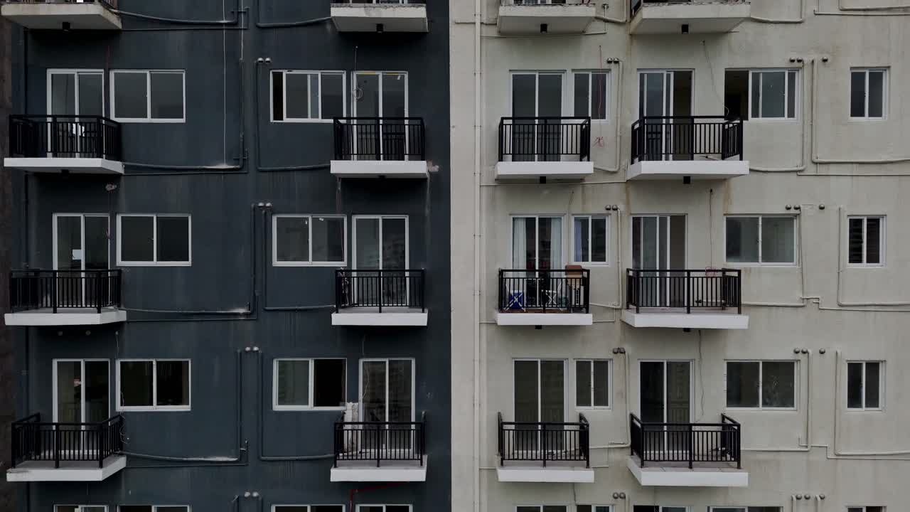 Rising shot of apartments on half black and white high rise building