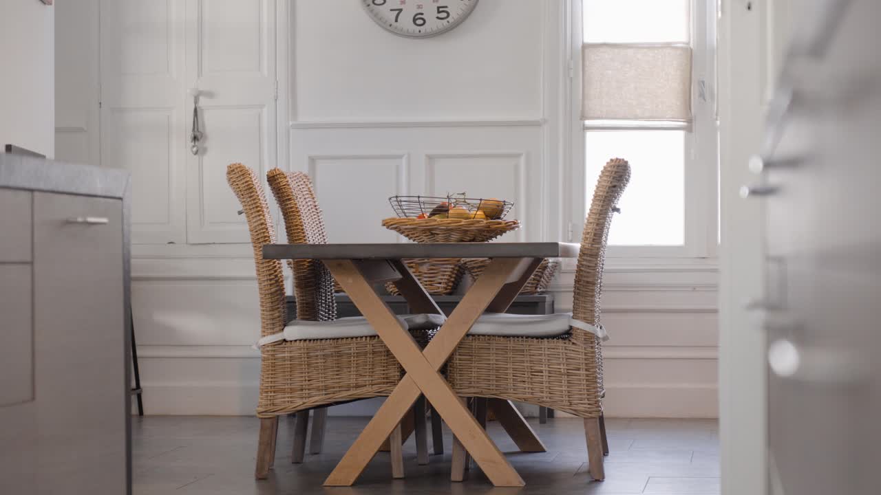 Slow establishing shot of a wicker table and chair set with fresh fruit on display