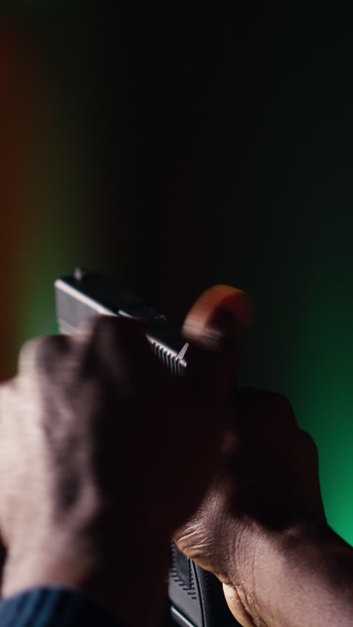 Vertical video Man reloading handgun in indoor shooting range, close up