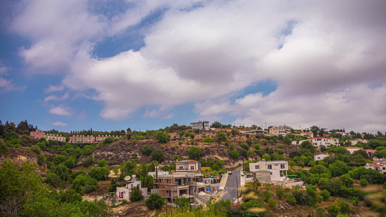 timelapse de un pequeño pueblo en la ladera de una colina en chipre con nubes barriendo los cielos