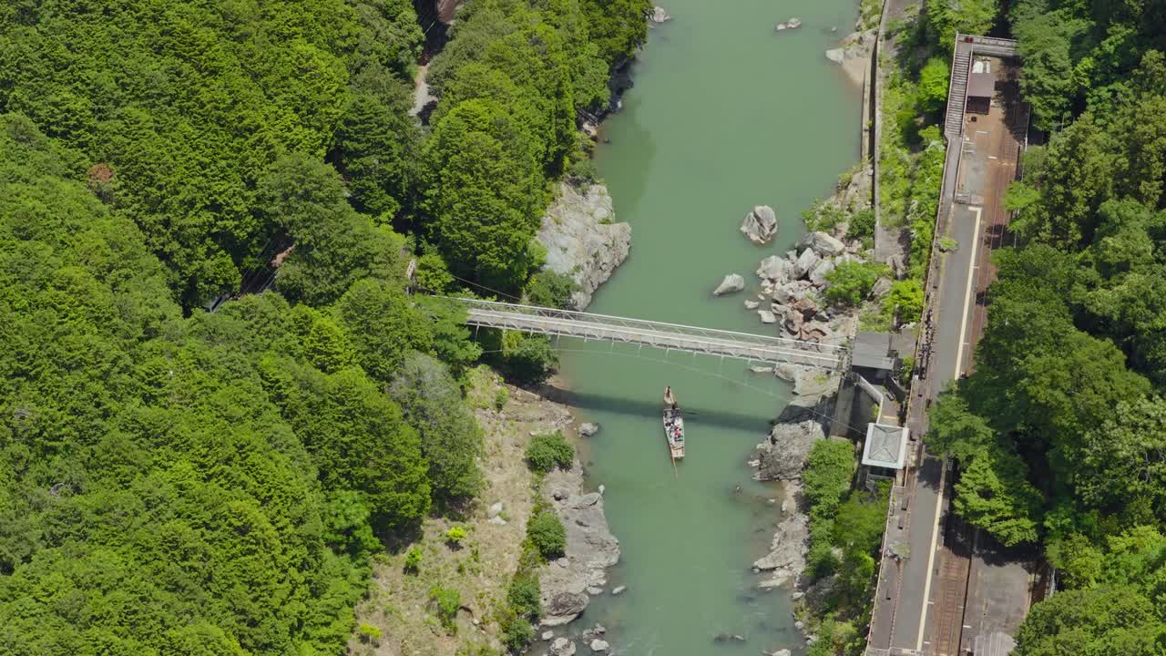 Aerial fly above boat ride on Hozu River cruise, Kyoto Japan Famous touristic natural area between Forested Mounts