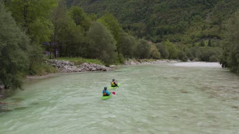 Aerial-shot-of-two-kayaks-going-down-the-emerald-alpine-river-Soca,-Slovenia