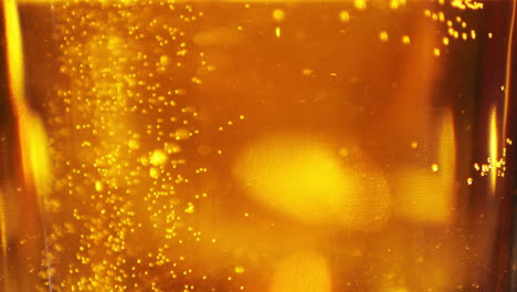 extreme close up of craft beer bubbles floating to the top of a pint glass