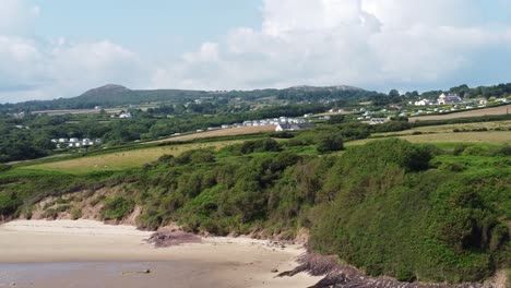 Schwenk-über-Den-Ackerland-Hügel-Von-Traeth-Lligwy-Anglesey,-Luftaufnahme-Mit-Blick-Auf-Die-Verwitterte-Walisische-Küste