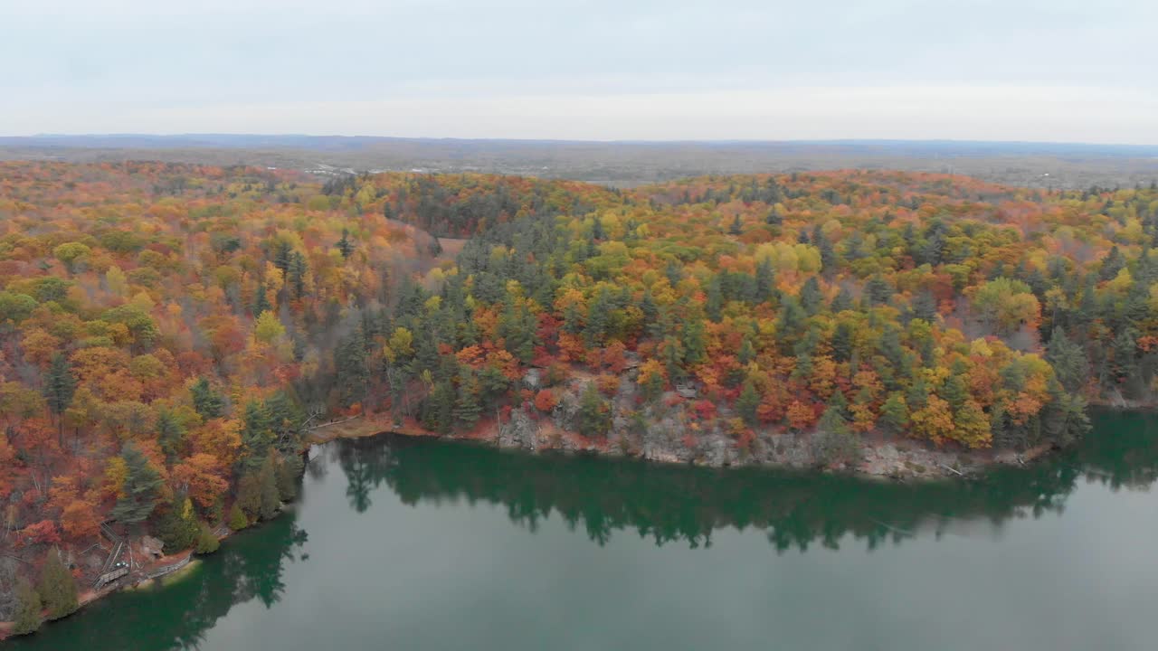 imágenes aéreas que circulan alrededor de un mirador en la ladera de una colina junto al lago rosa en gatineau, quebec, sobre paseos marítimos y miradores con gente