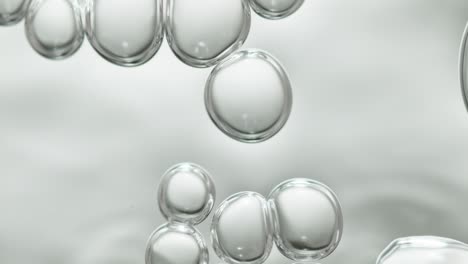 upwards drifting transparent bubbles in low angle on white background