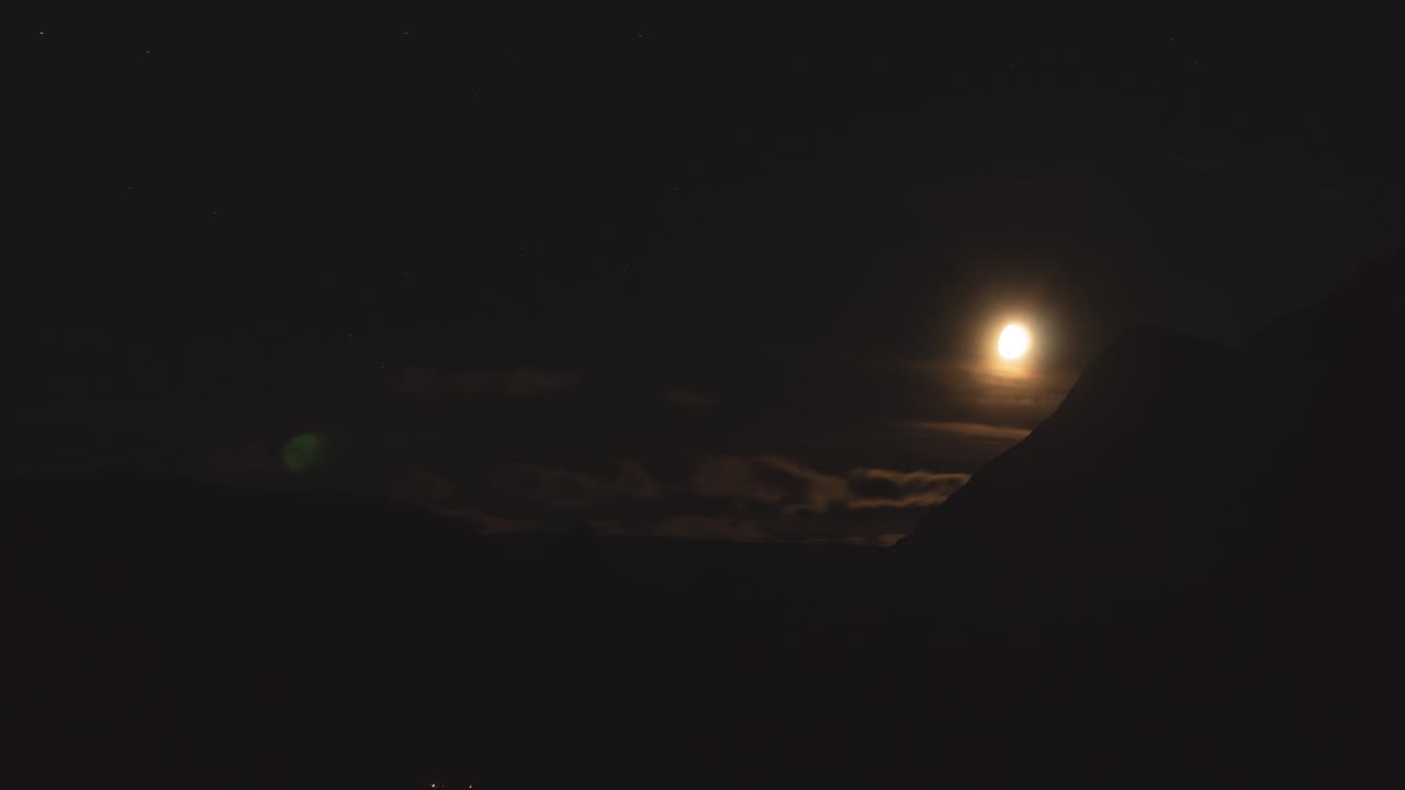 Beautiful time lapse of a rising moon, clouds passing by