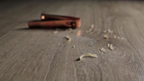 rose gold nail clippers and nail clippings on wooden surface