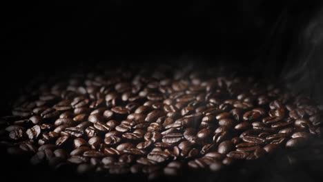 rotating shot of roasted coffee beans with smoke abience