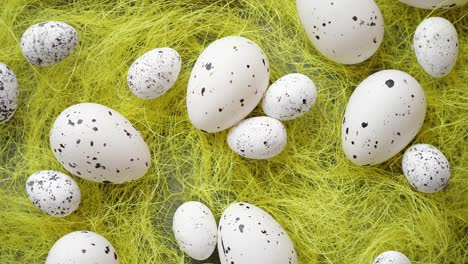 white easter eggs with freckles placed on the yellow hay