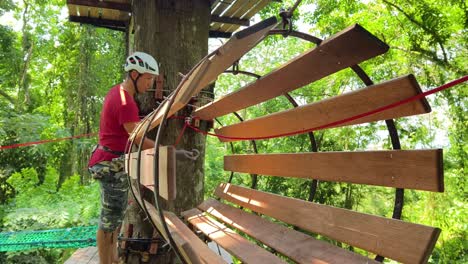 person working on a treetop adventure park platform