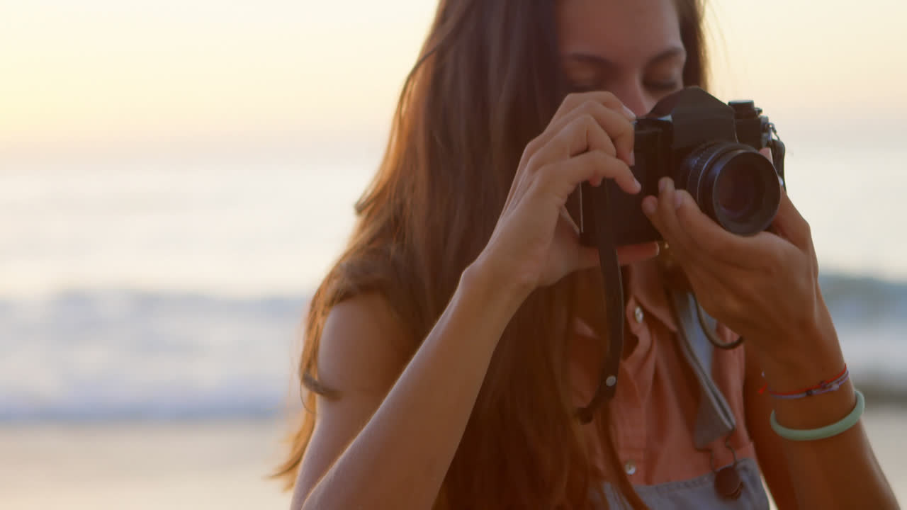 Donna che scatta foto con la macchina fotografica sulla spiaggia 4k