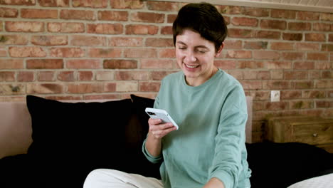 woman using phone on bed